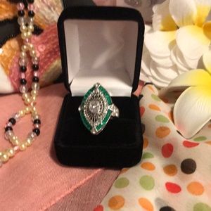 Silver ring with clear and green color stones.